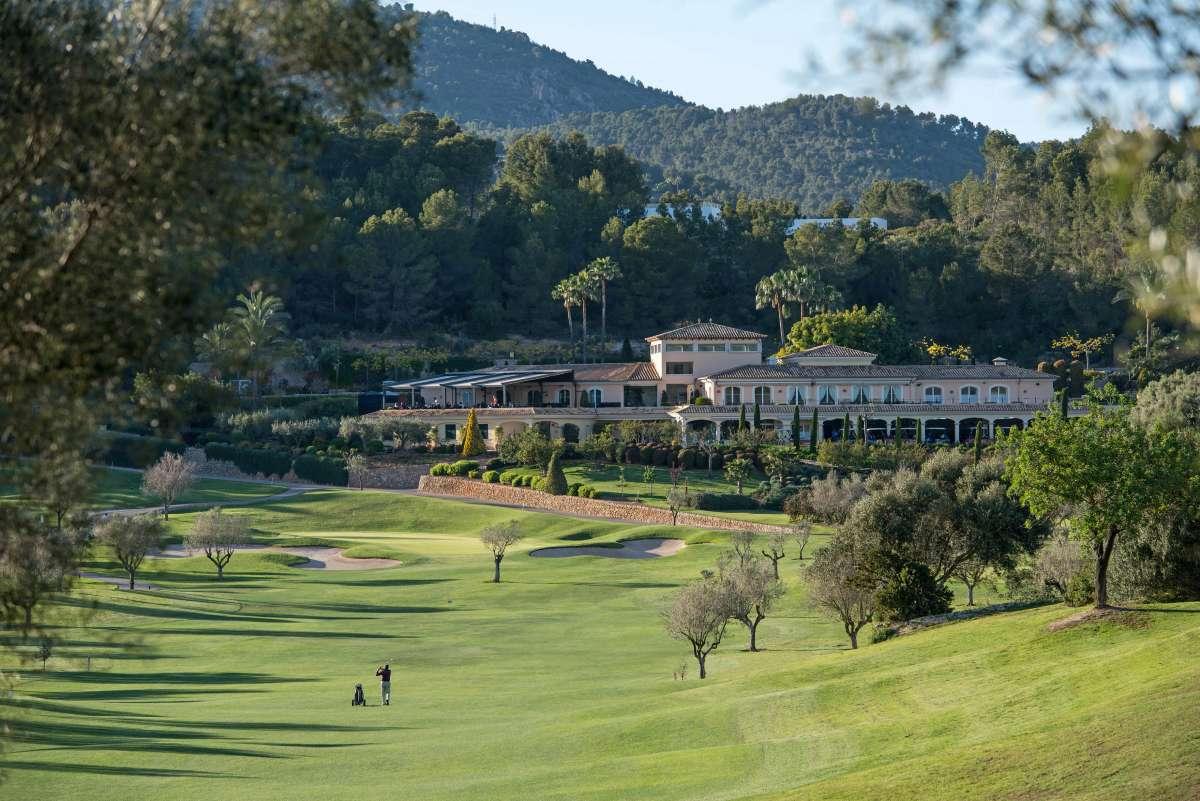 Undulating fairway with the clubhouse in the background, surrounded by lush greenery