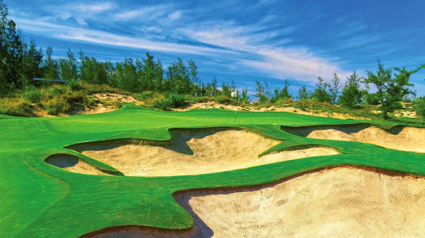 A smooth green surrounded by deep sand bunkers on the BRG Da Nang Golf Resort course