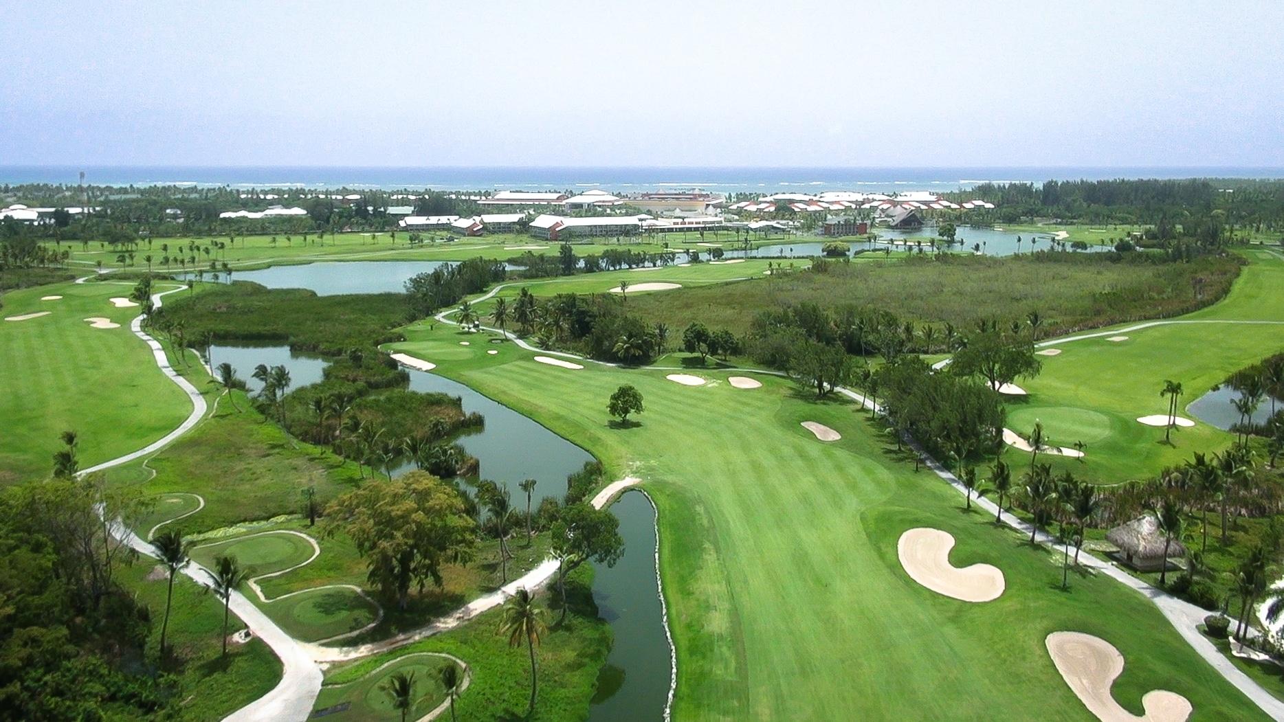 A wide fairway nestled with sand bunkers leading to a manicured green