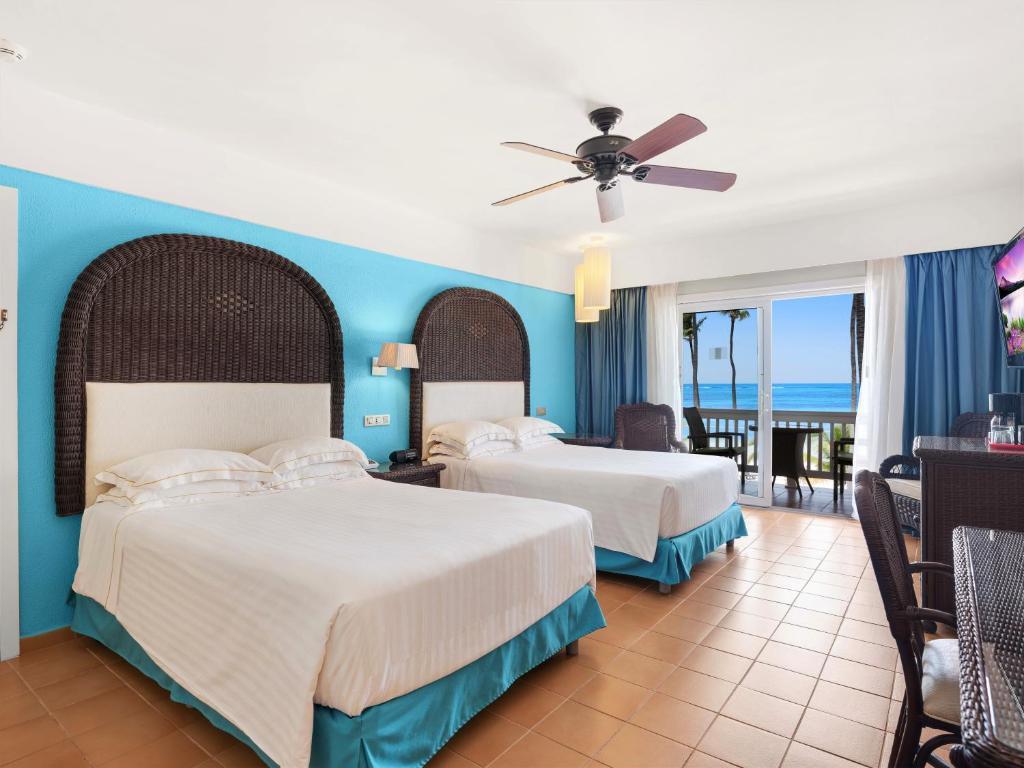 Twin doubled bed room with a blue theme and balcony views of the beach