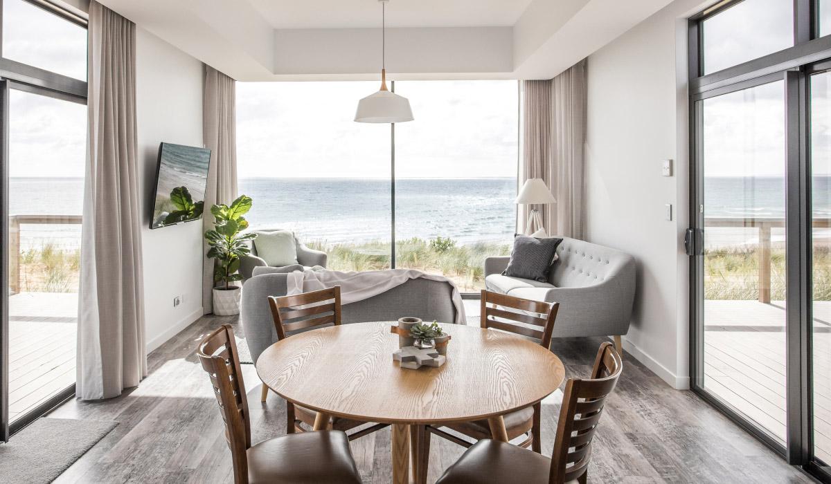 A modern living room as part of a lodge with panoramic windows for ocean views