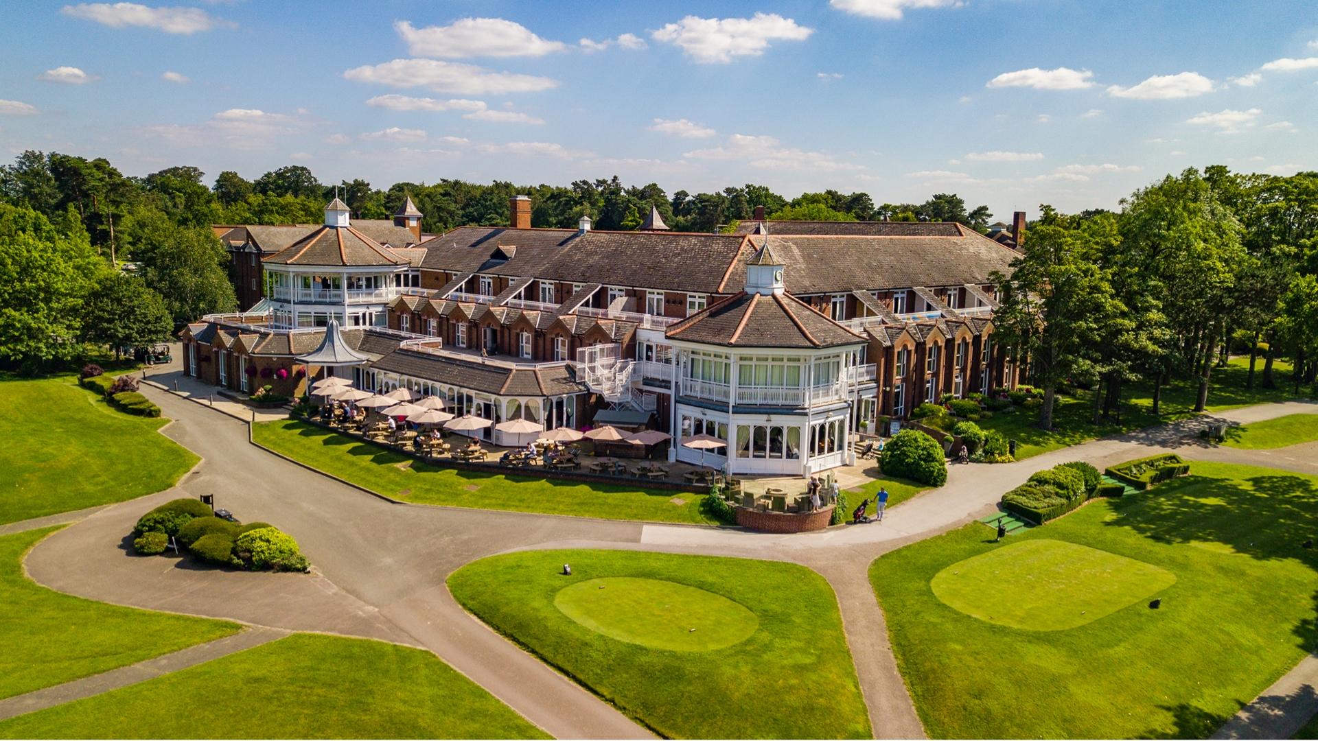 The Belfry clubhouse with an outdoor seating area to observe others enjoy their round of golf on the course