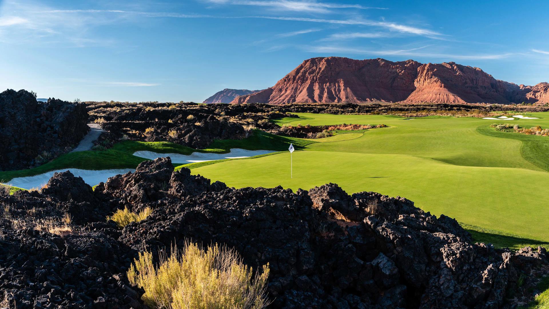 A smooth green nestled with sand bunkers at the end on a wide fairway