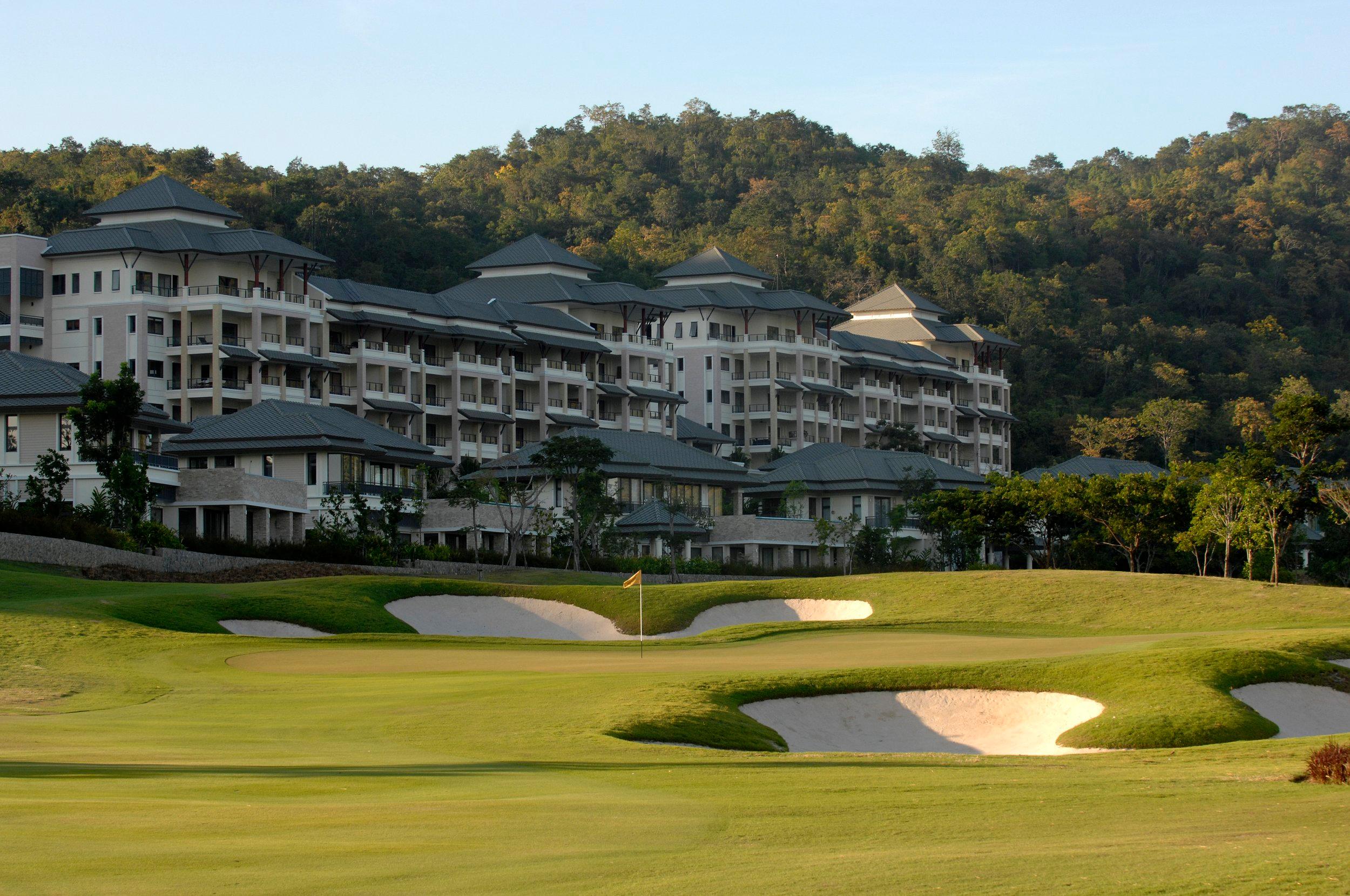 The Black Mountain Golf Club & Resort building overlooking a smooth green surrounded by sand bunkers
