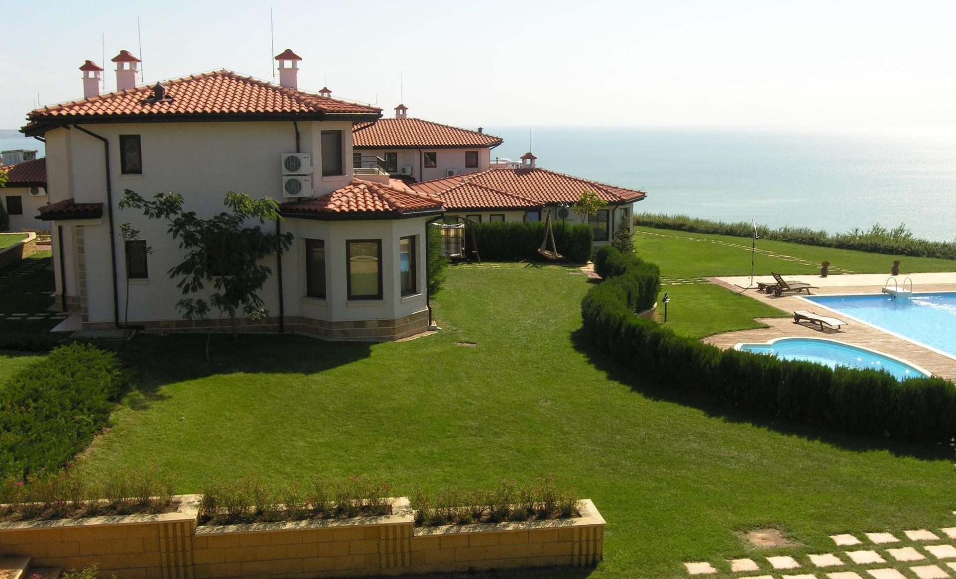 A personal swimming pool as part of a villa with coastal views and a well maintained garden