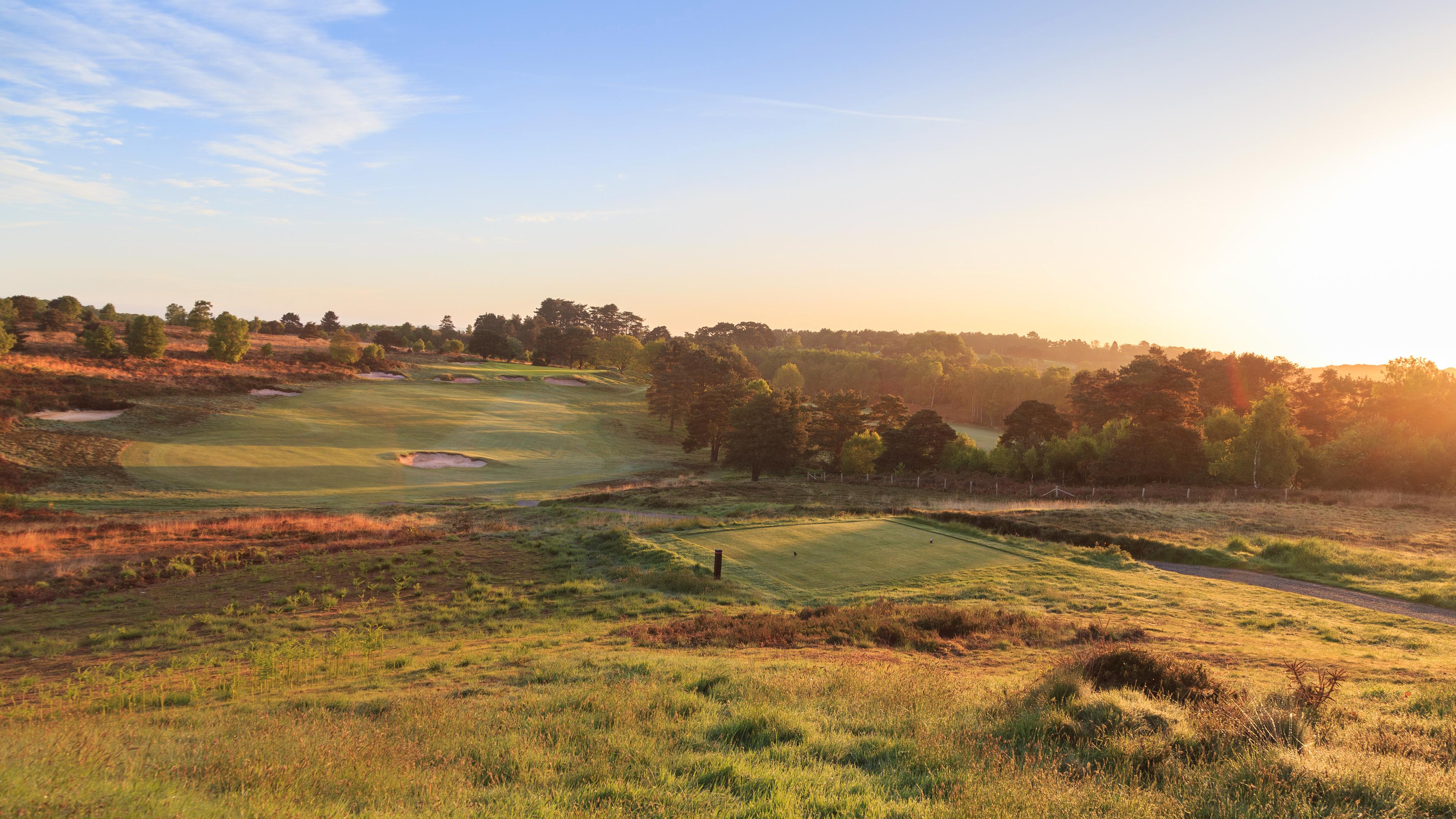 Overhead view of the sun setting over the Broadstone Golf Club course