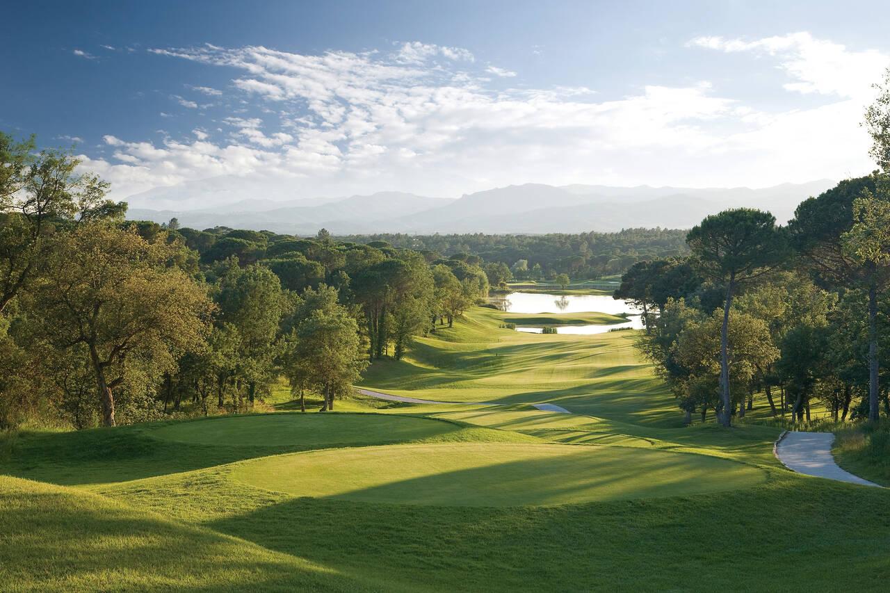 View from a tee box of an undulating, tree-lined fairway leading up to water on the Stadium Course