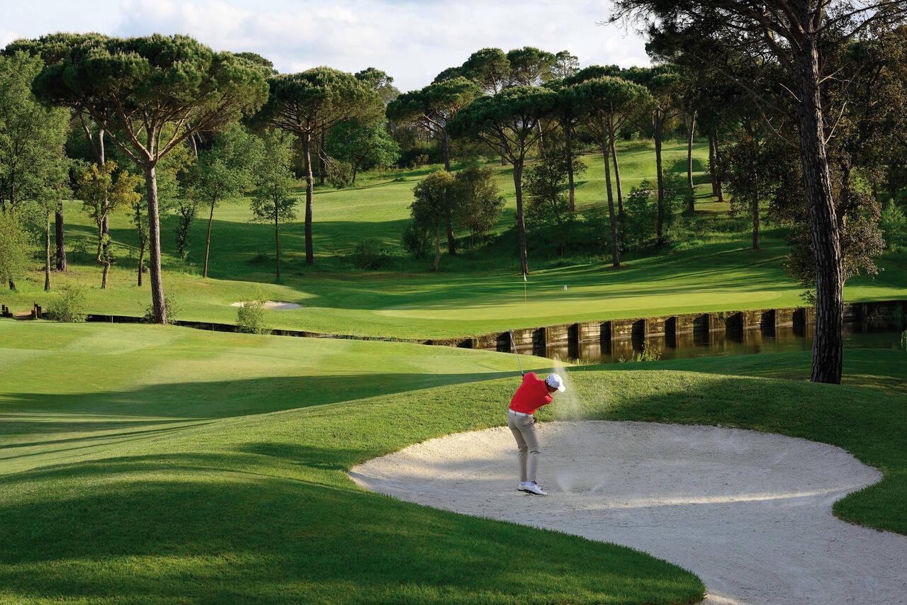 Player playing out of a bunker of water to the green on the Stadium Course