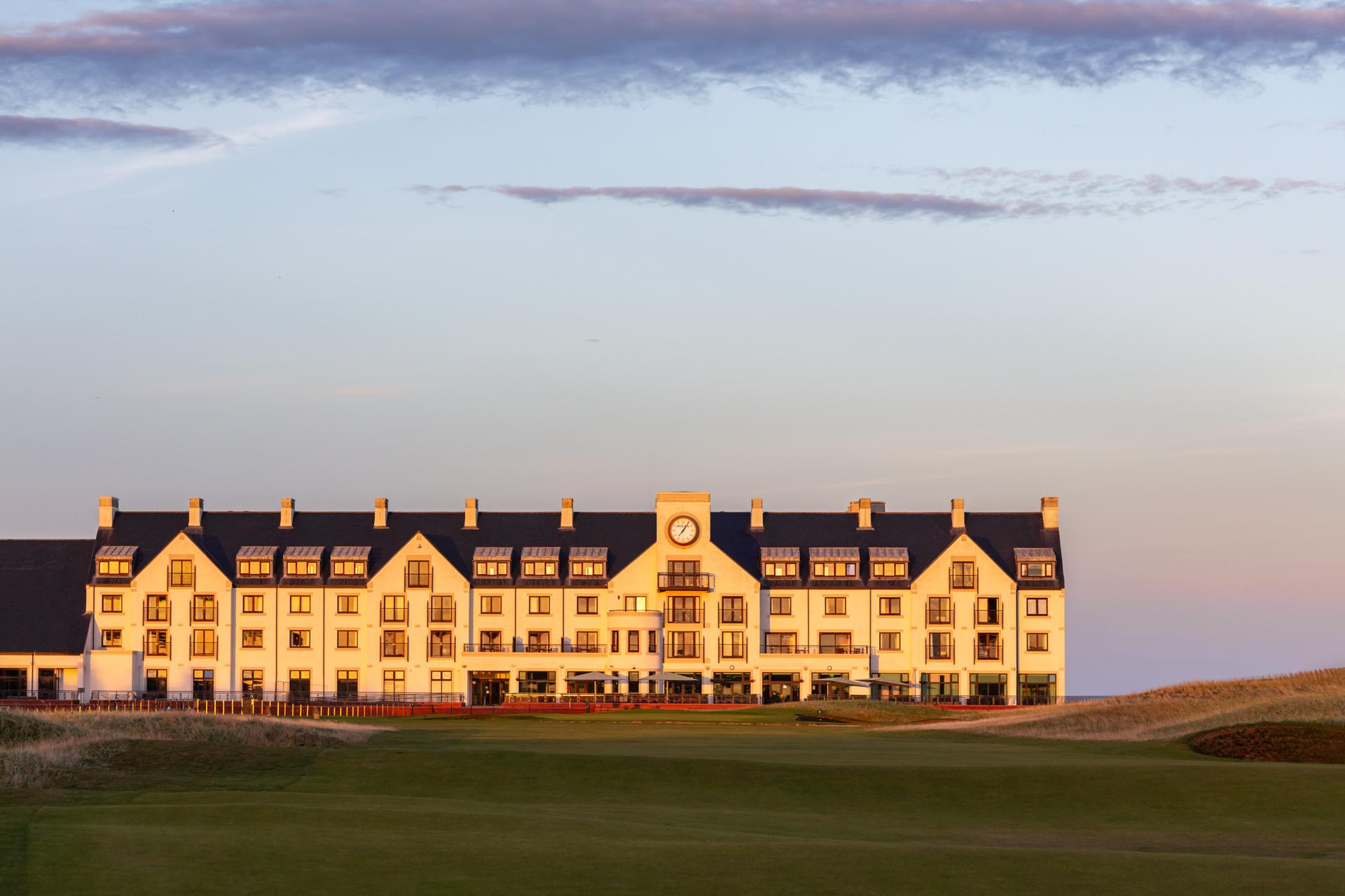 Sun settting over the resort building featuring a clock in the centre of the building looking out onto the course
