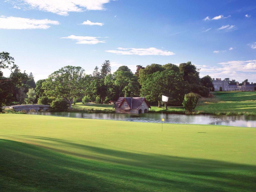 A scenic stone bridge crosses the water near a putting green.
