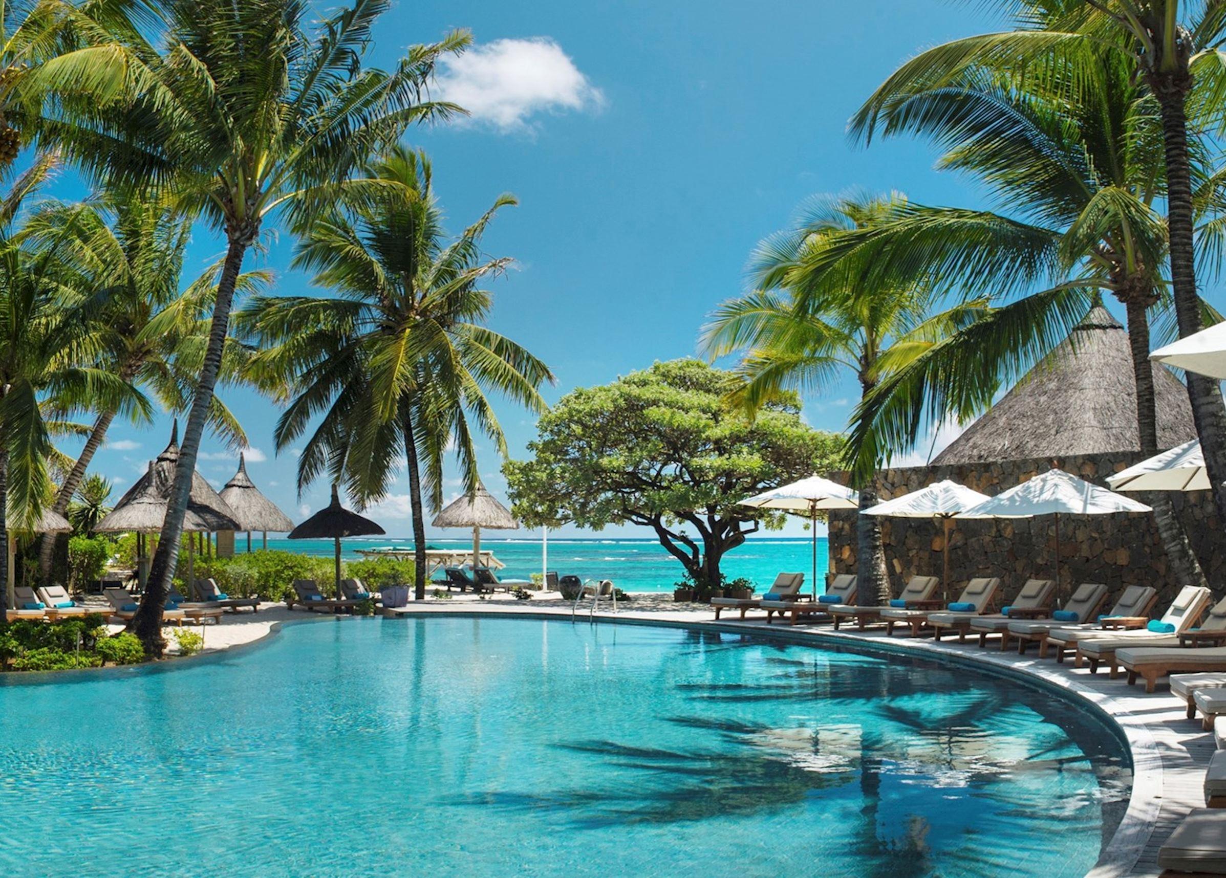 Outdoor swimming pool at the resort framed by palm trees and sunbeds