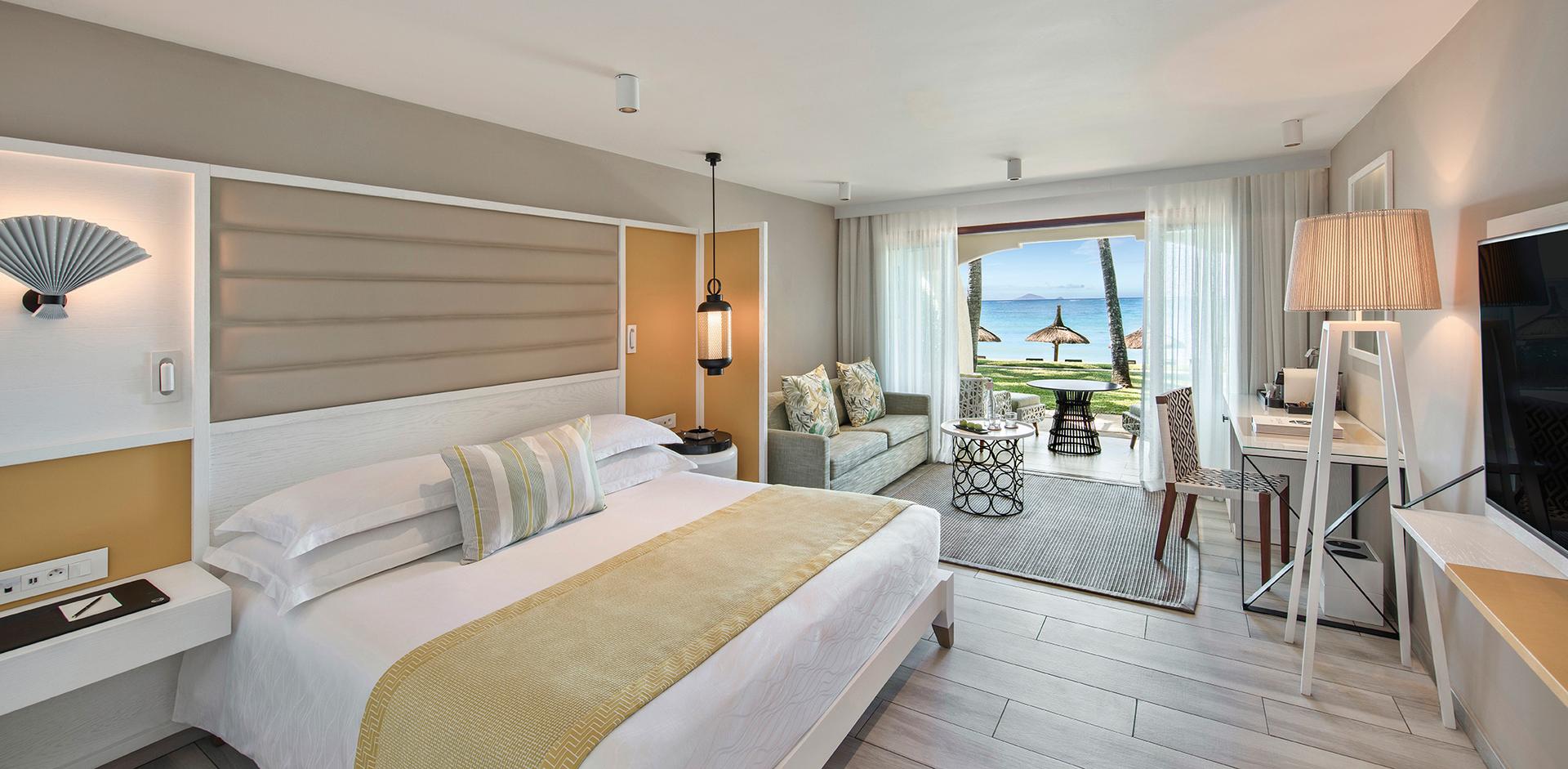 Double bed suite at the resort with a sofa area and patio leading to the beach