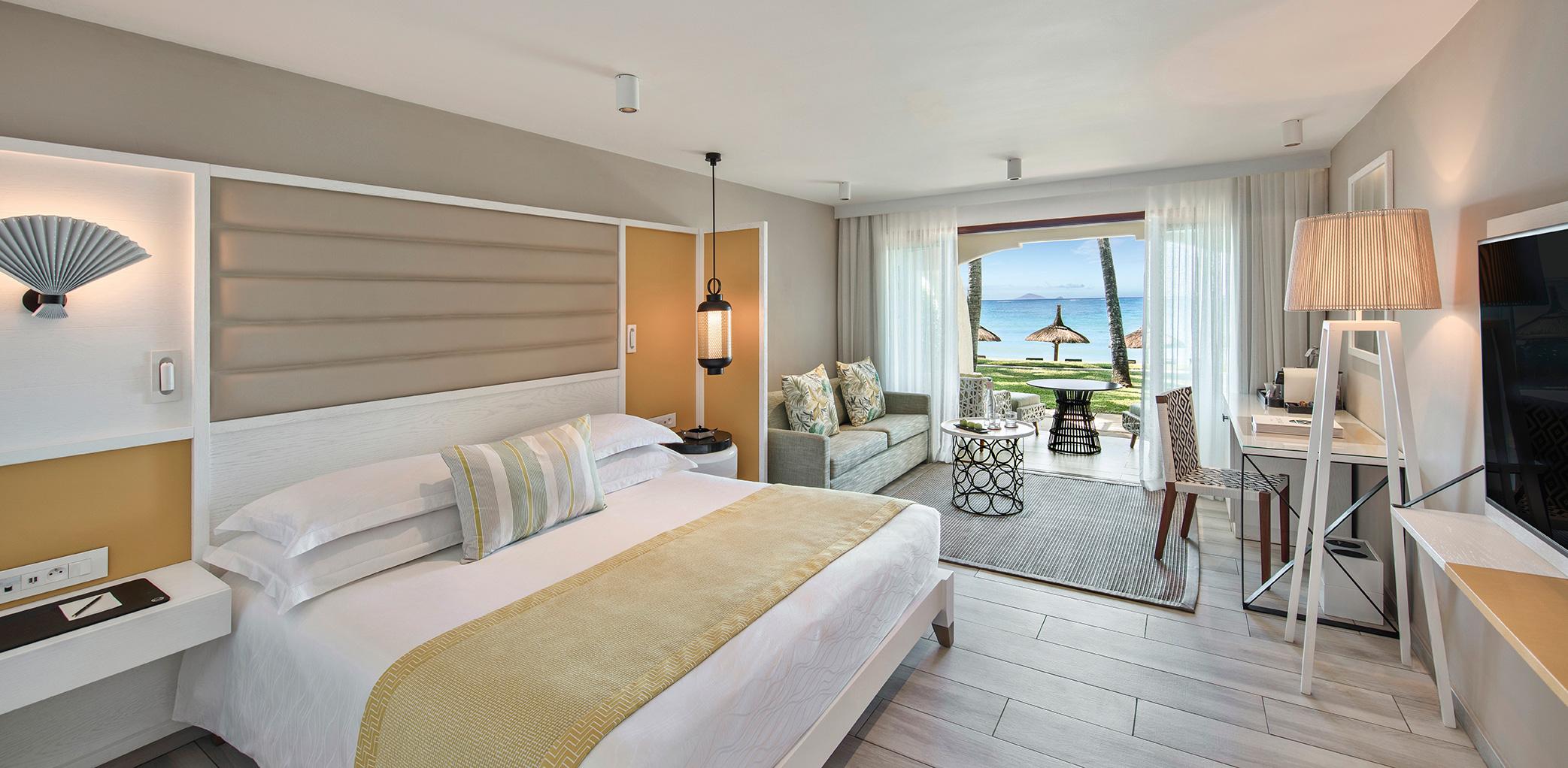 Double bed suite at the resort with a sofa area and patio leading to the beach
