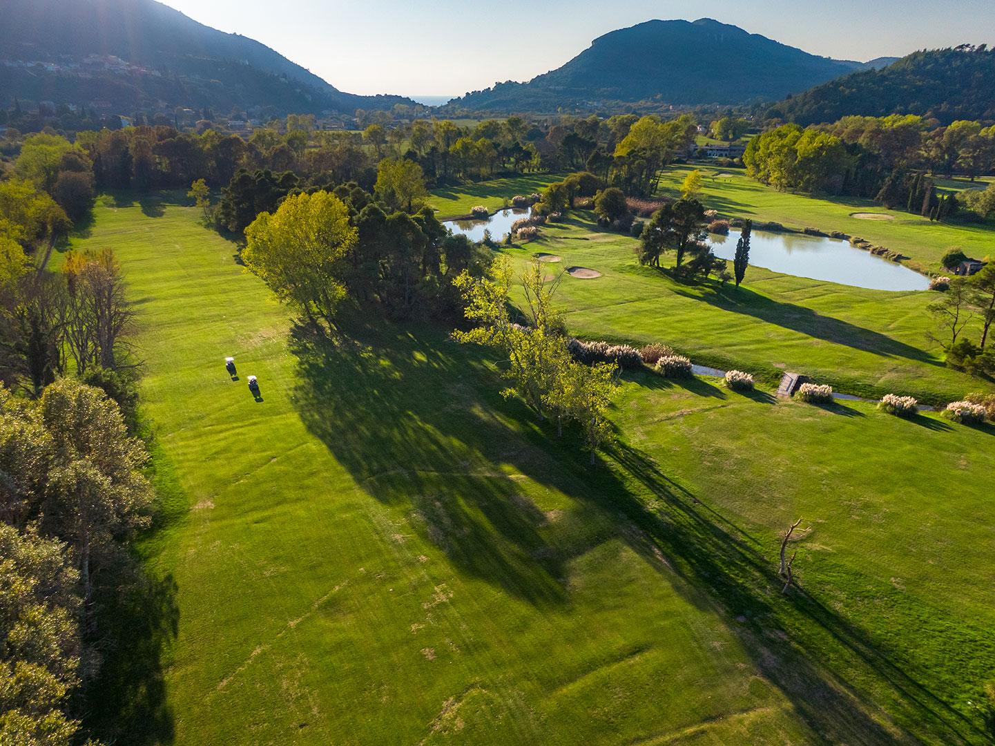 Birdseye view of golfers driving their buggies down a wide fairway