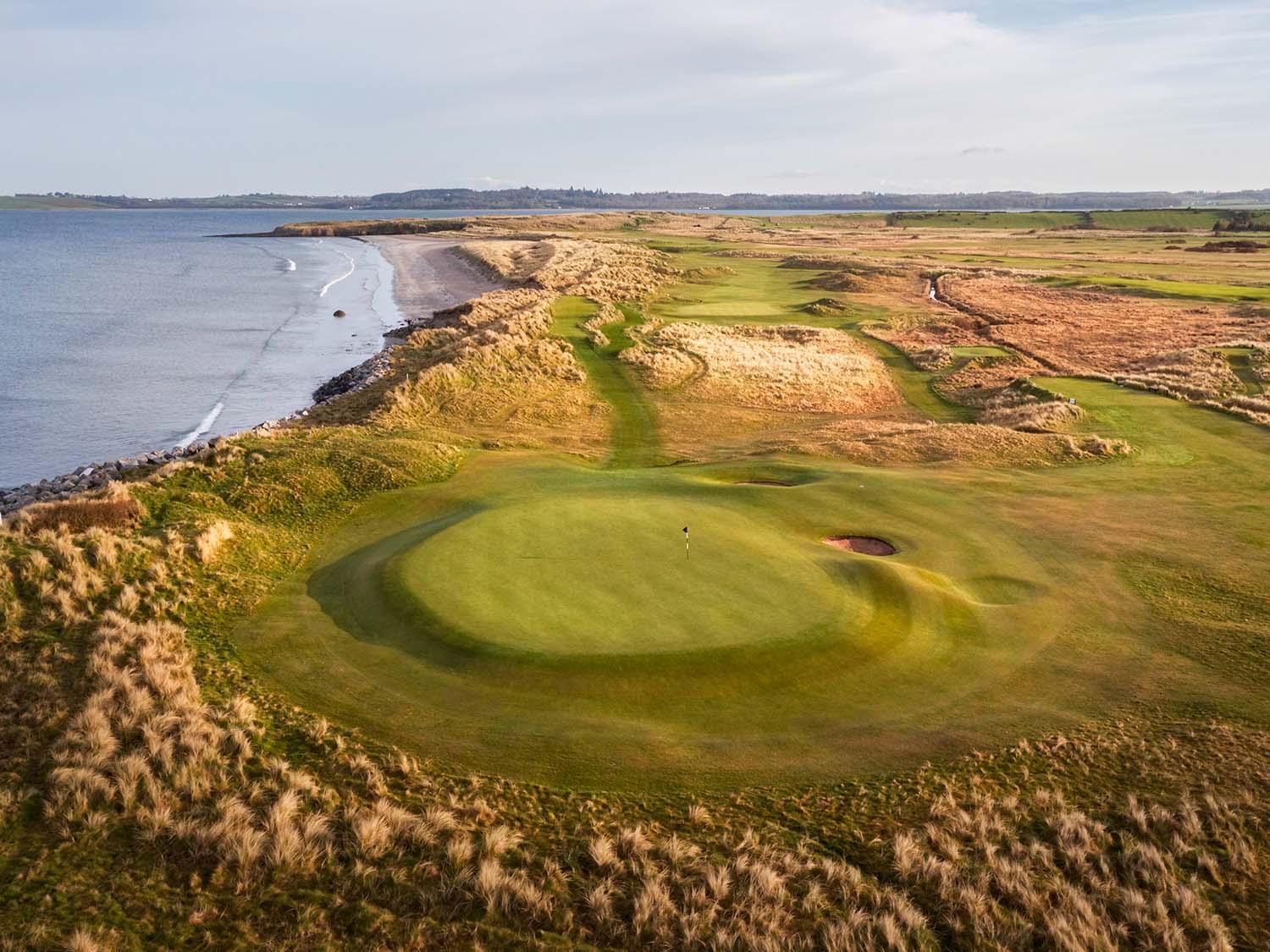 Elevated shot of putting greens which overlook the ocean just behind the hole