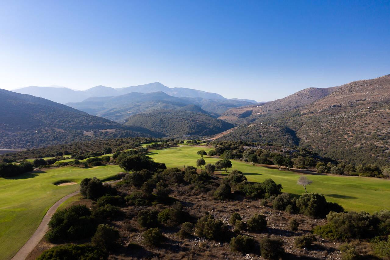 Aerial view of the course nestled among rocky hills.