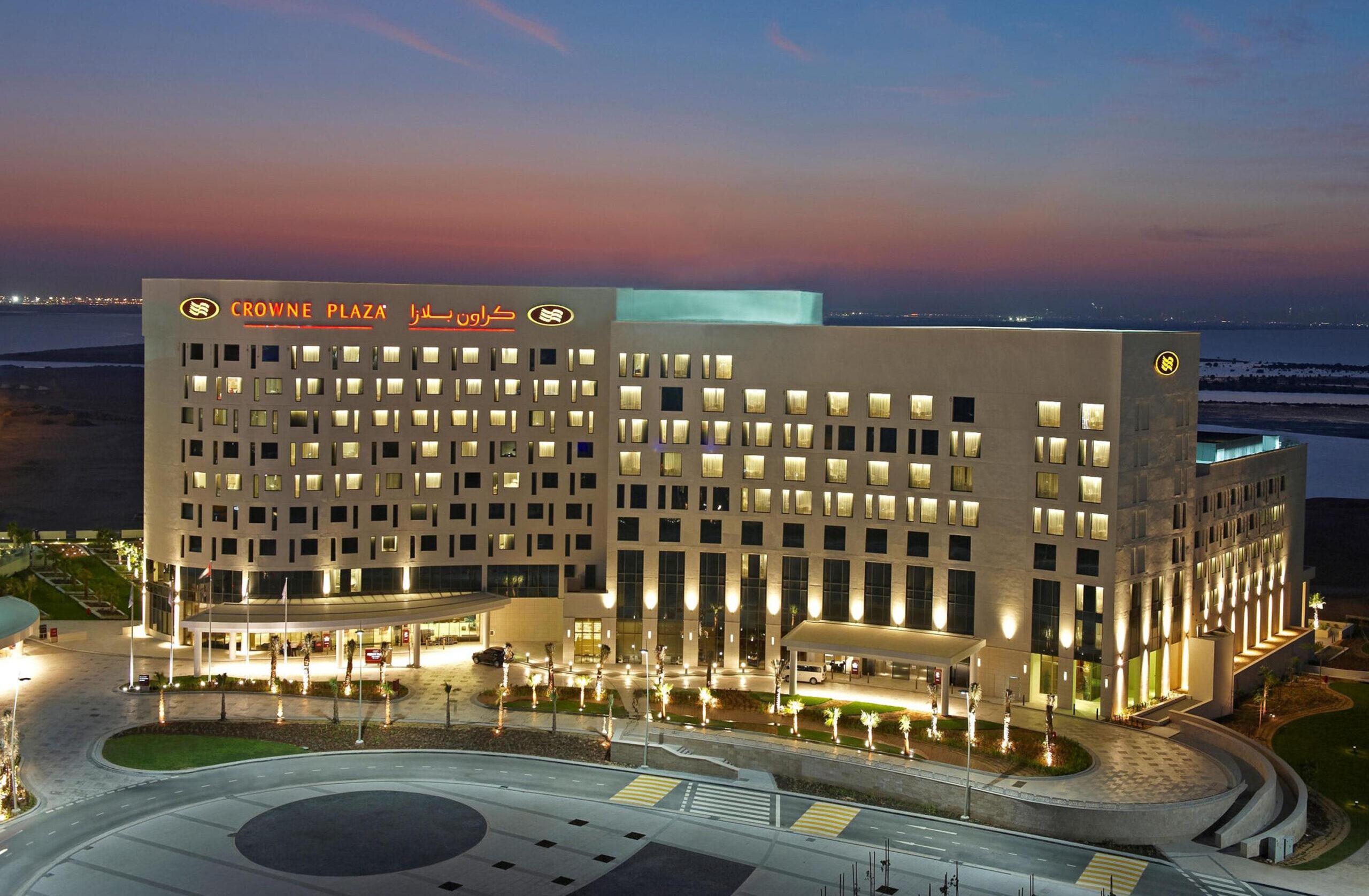 Aerial view of the Crowne Plaza Yas Island hotel building with their name in red writing at the top