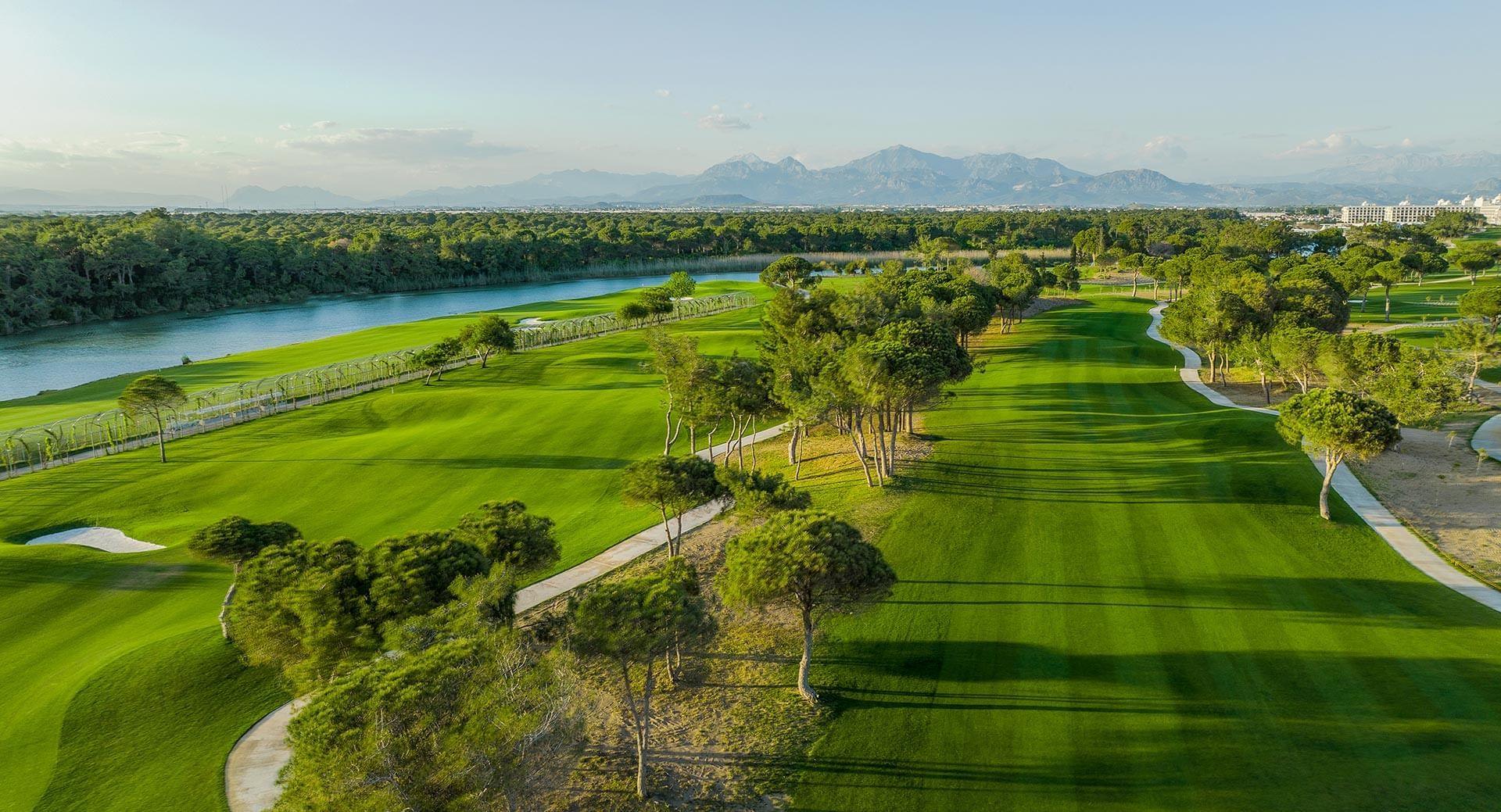 Manicured fairways with trees and mountains in the distance