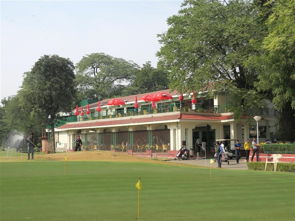 The Delhi Golf Club clubhouse with outdoor seating overlooks the golf course.
