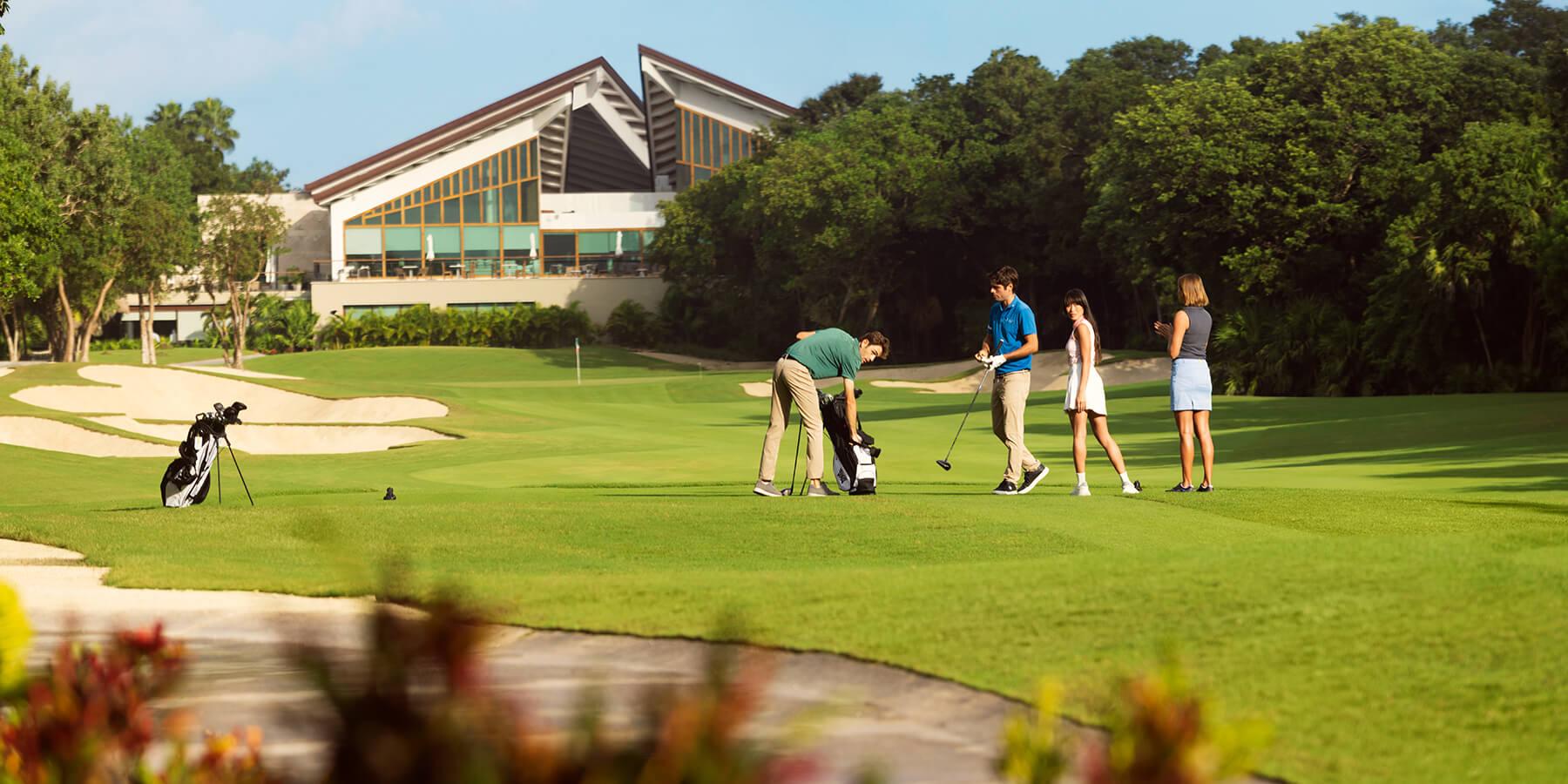Golfers enjoying their round of golf with the El Cameleon clubhouse towering over them