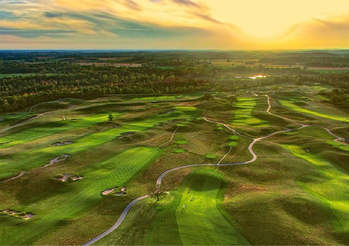 Overhead shot of golfers enjoying their round of golf on smooth greens at sunset