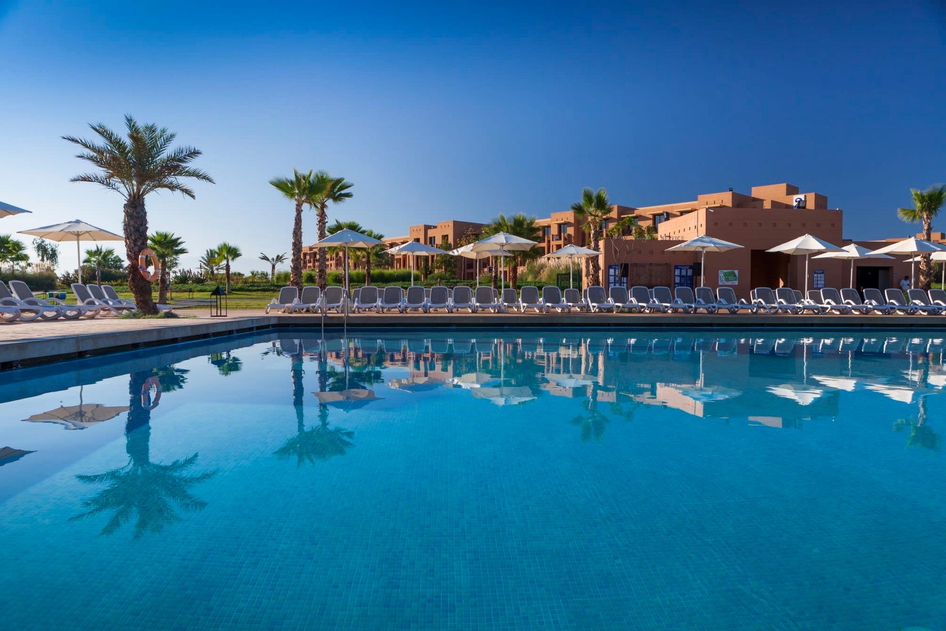 Outdoor swimming pool framed by sunbeds at the Fairmont Royal Palm Marrakech