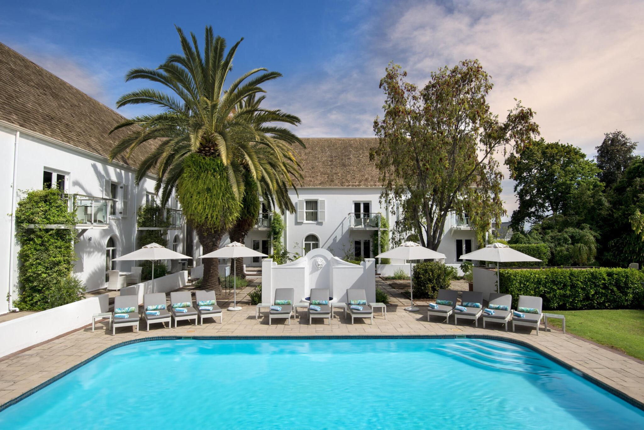 A swimming pool at Fancourt Hotel & Golf Estate surrounded by sunbeds
