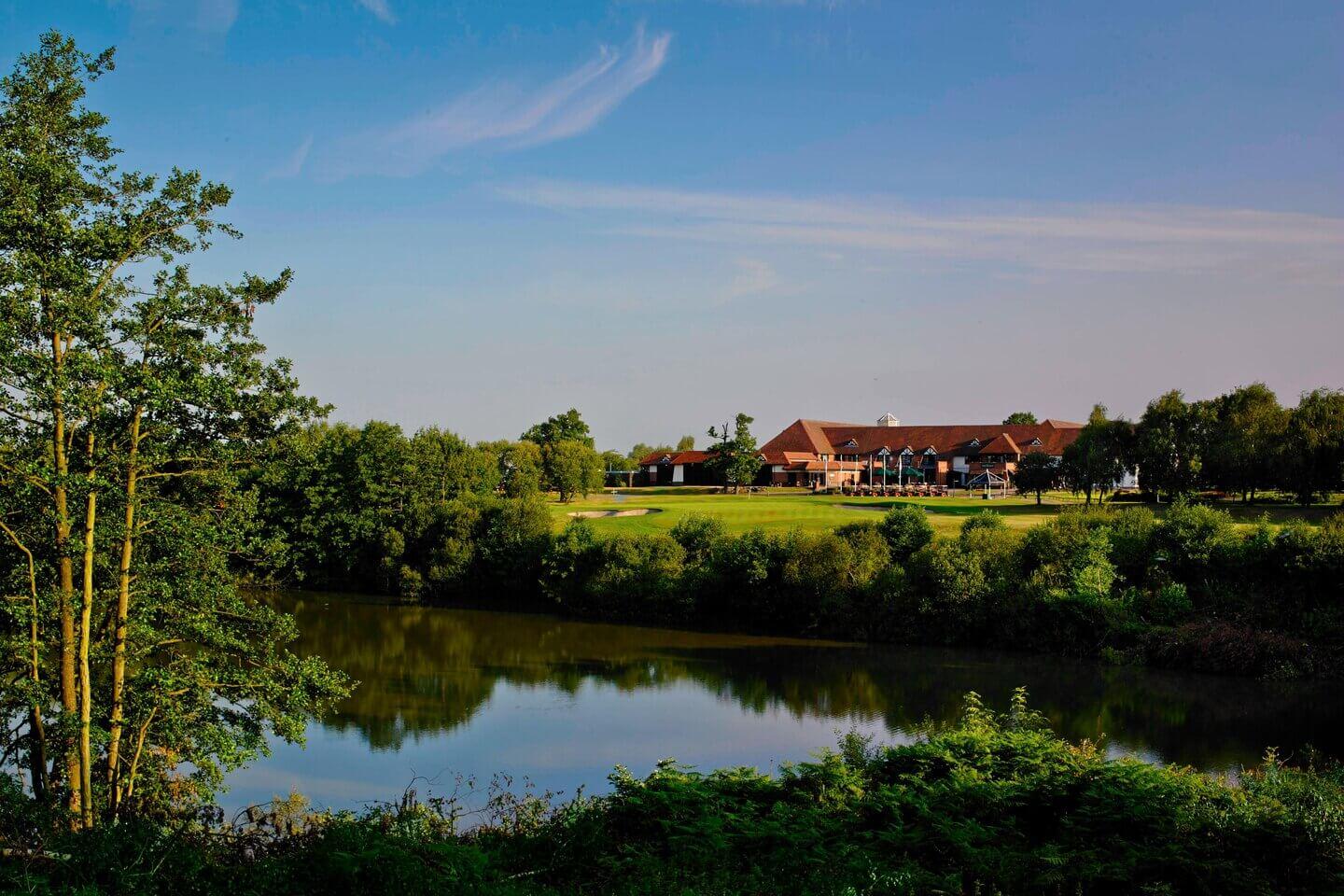 Golf clubhouse near a reflective water body.