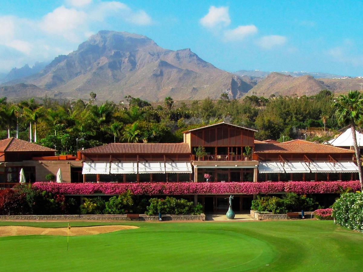 Outside view of the Golf Las Americas clubhouse with the mountains behind
