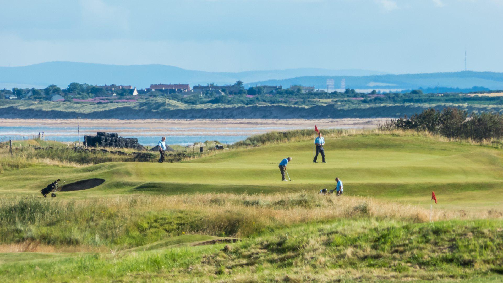 Golfers enjoying their round of golf at the Golspie course with sea views in the back