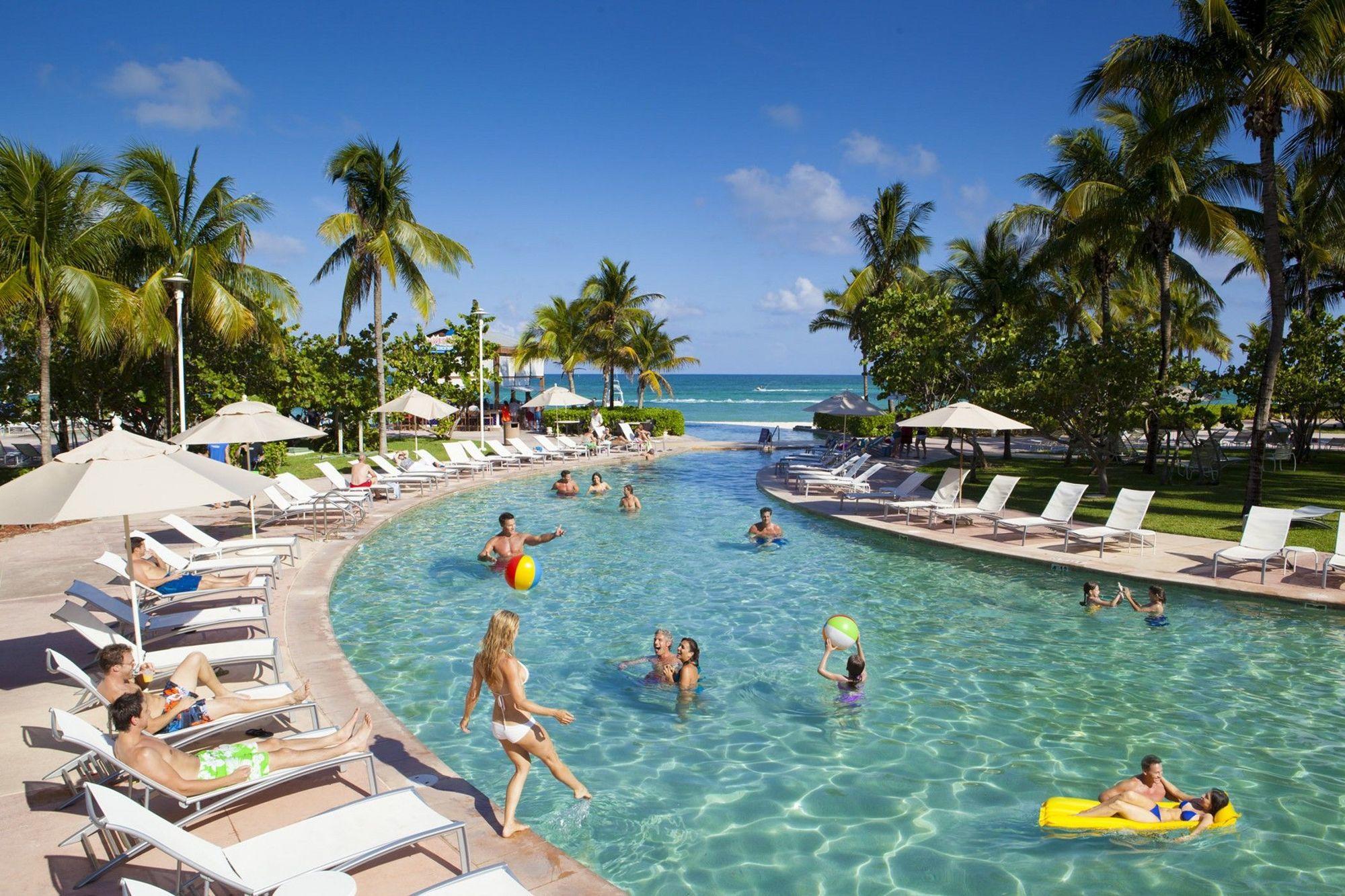 Guests enjoying the swimming pool that leads to the sea at the Grand Lucayan resort