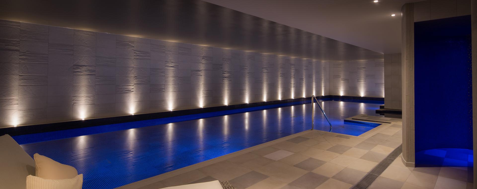 Indoor swimming pool illuminated by poolside lights at the Hilton Bournemouth