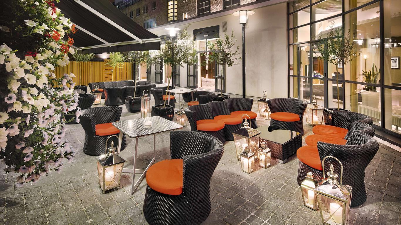 Stylish outdoor seating area at Hilton Dublin, featuring lanterns and vibrant decor.