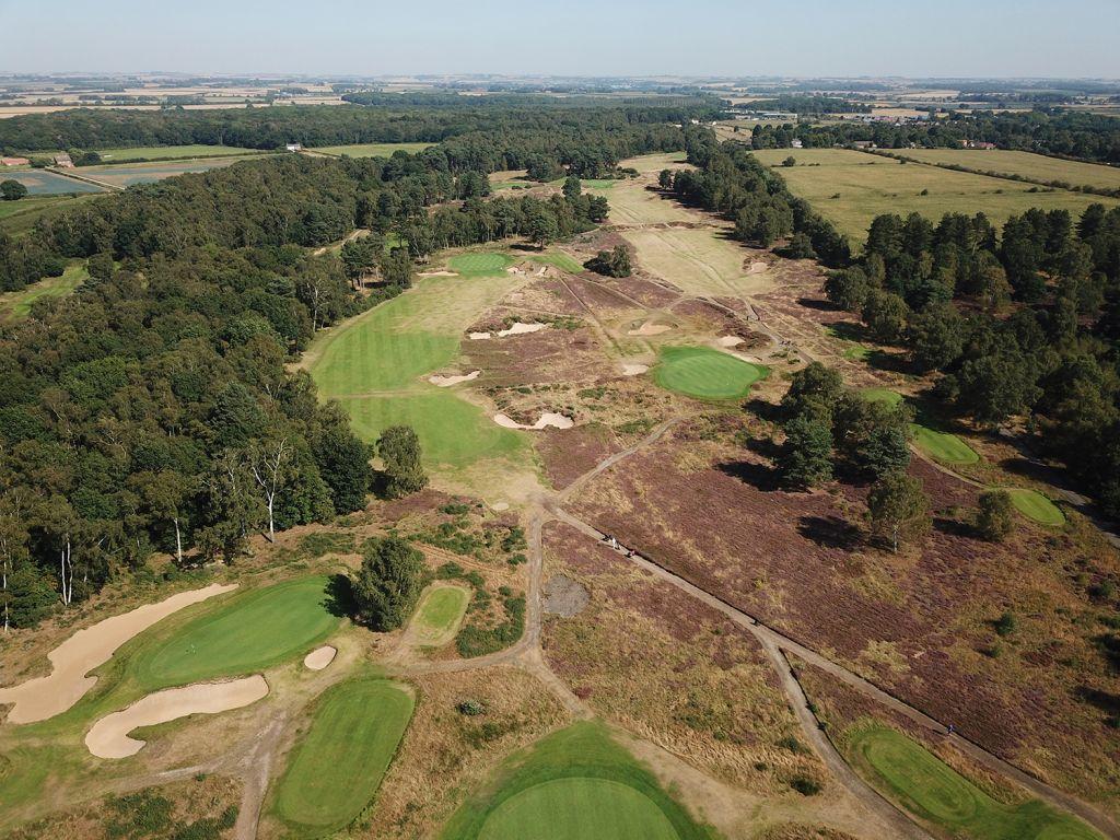 Aerial view of a golf course with fairways and greens spread across open terrain