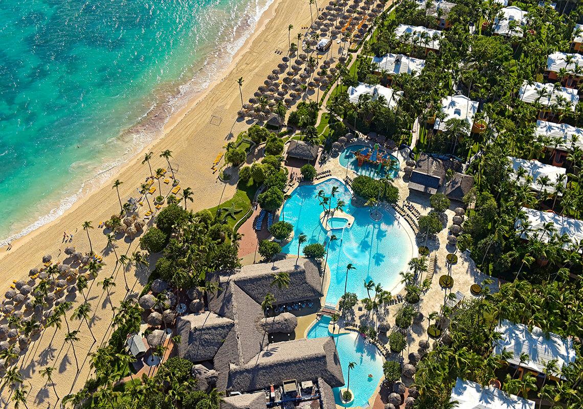 Overhead view of the swimming pool leading to the beach nestled with palm trees