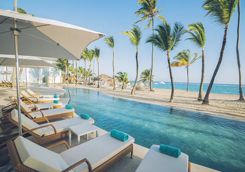 Iberostar Bavaro Selection Suites infinity pool leading onto the beach nestled palm trees