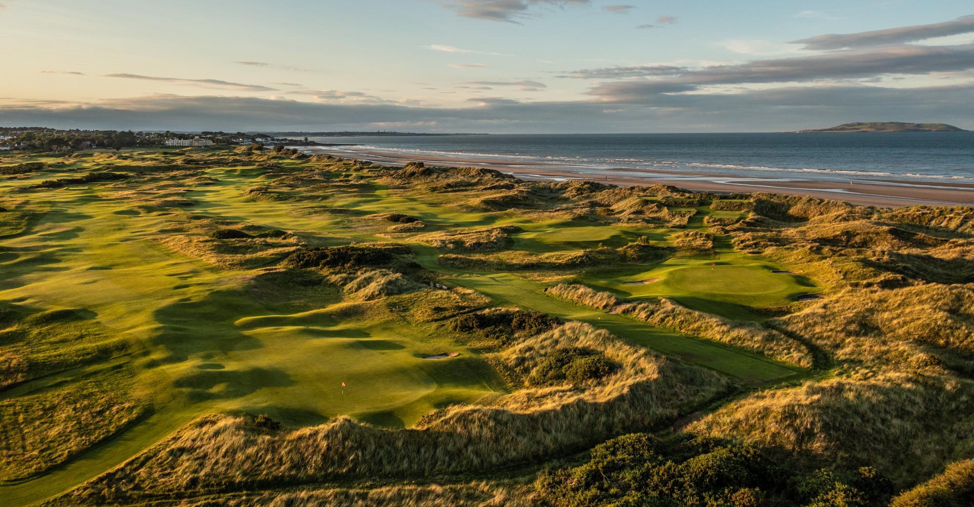 A stunning aerial view of a links-style golf course beside the ocean.
