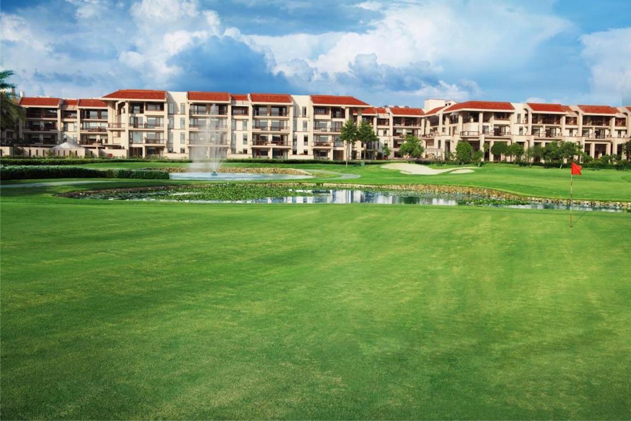 The Jaypee Greens Golf Resort building overlooking a smooth green