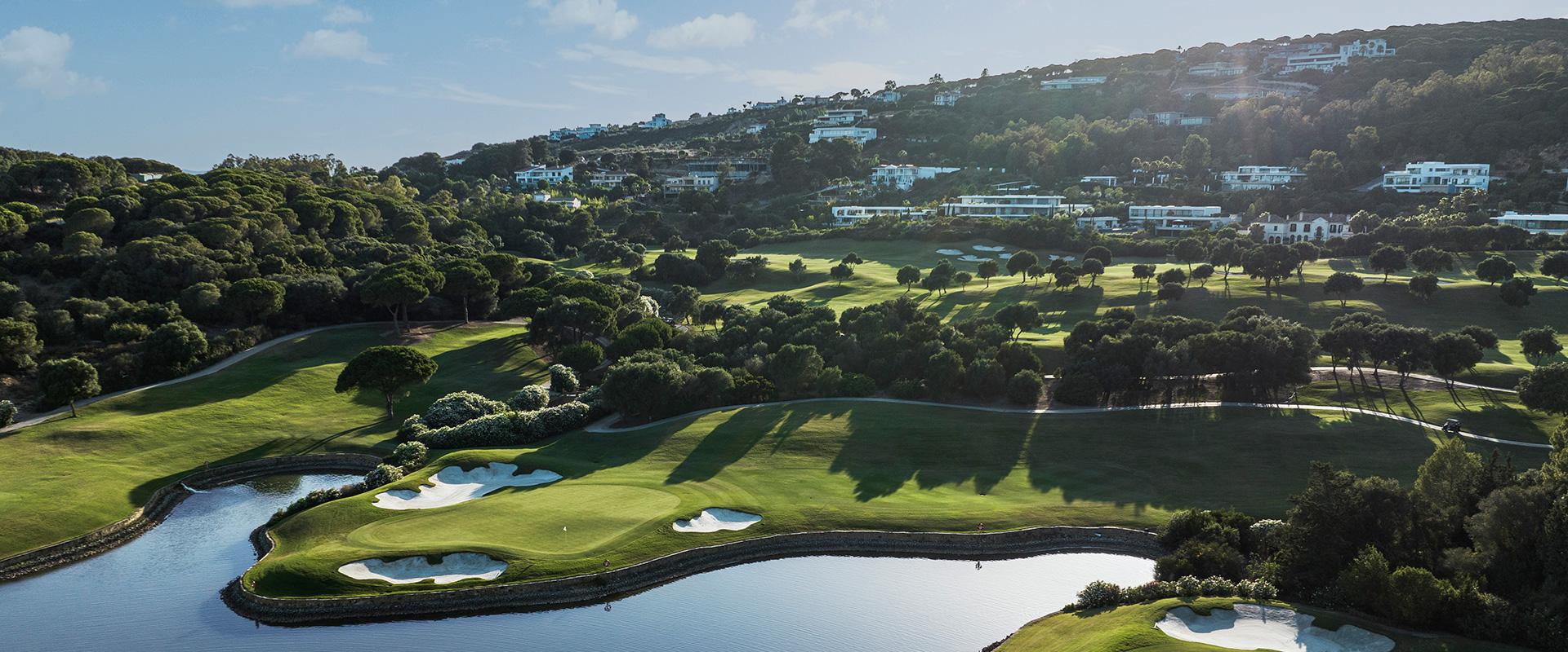 Aerial view of a green surrounded by bunks and a water hazard