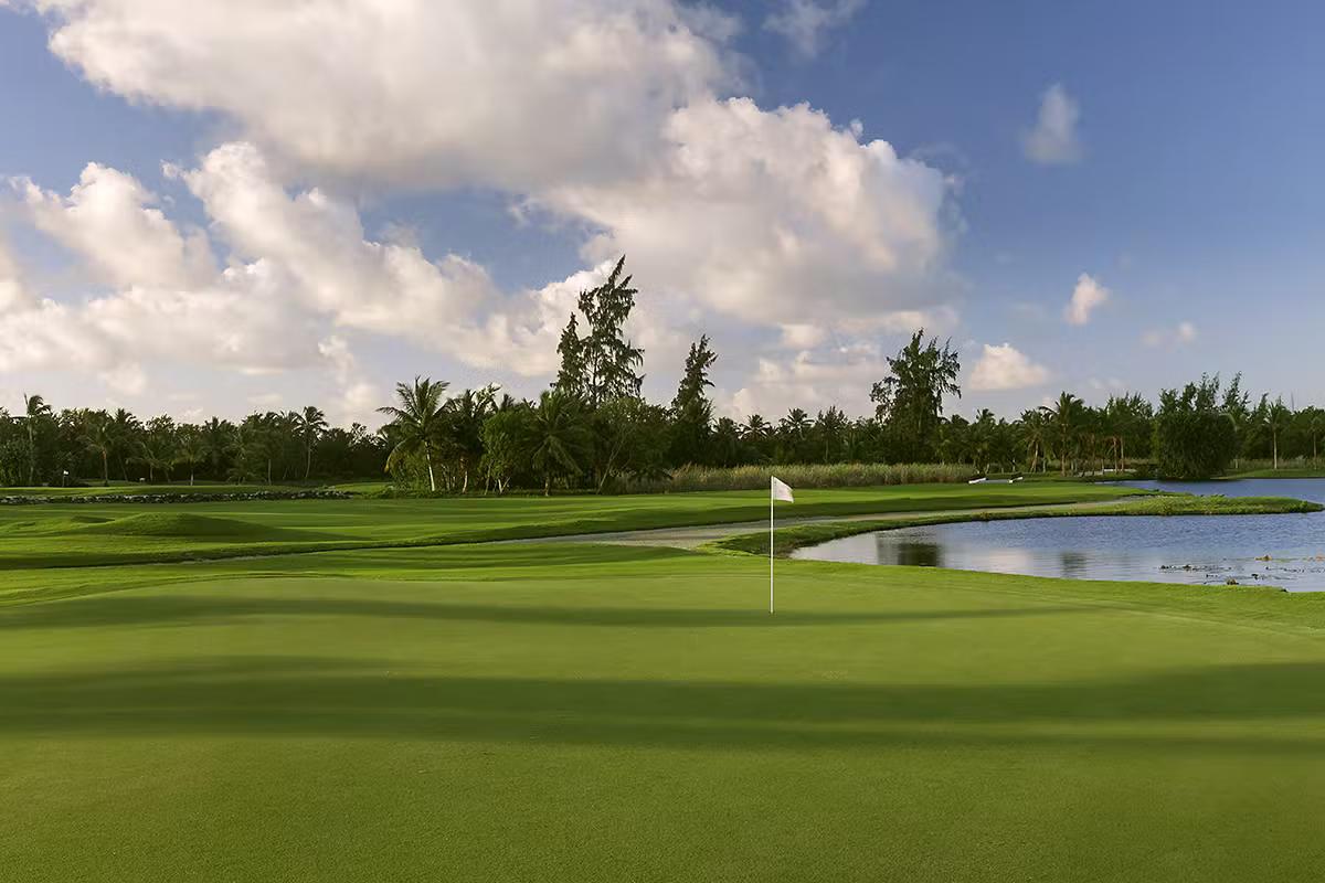 A smooth green placed next to a water feature