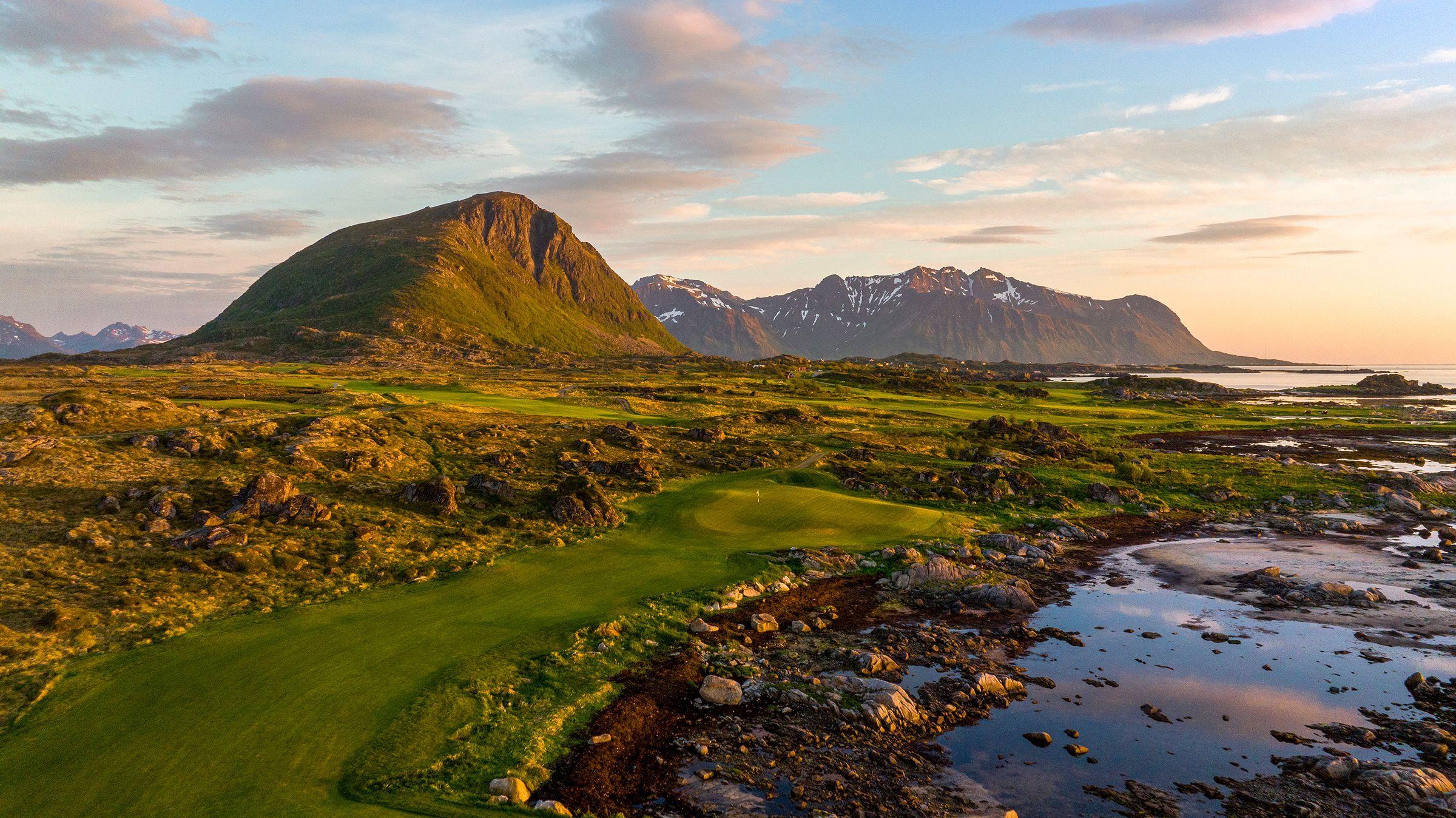 A well maintained fairway leading to a smooth green surrounded by a rocky rough