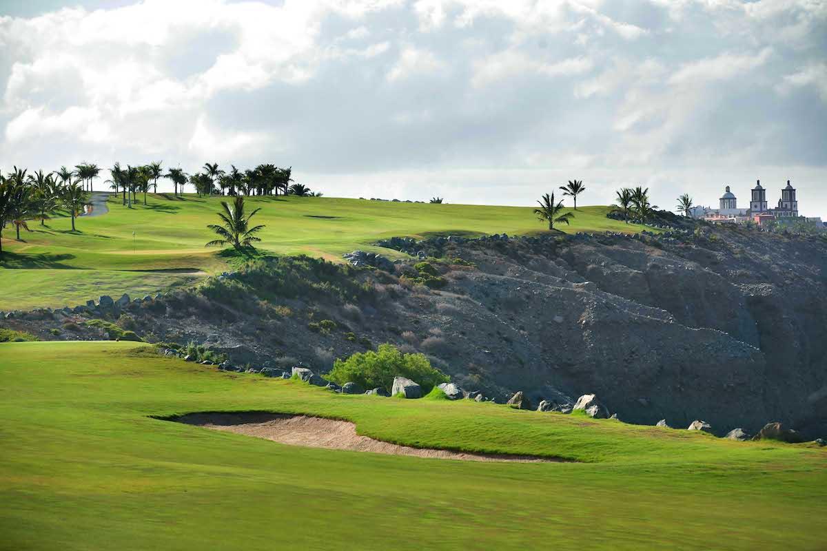 View of one of the cliffside fairways on the back 9 with the Lopesan Villa del Conde in the background