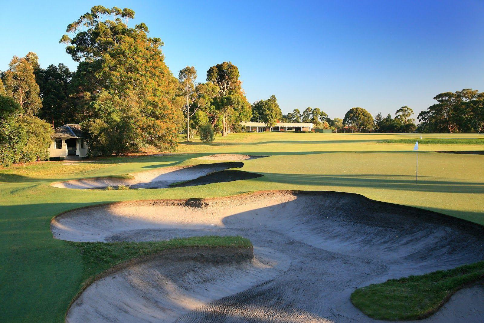 A manicured green surrounded by deep sand bunkers at The Metropolitan Golf Club