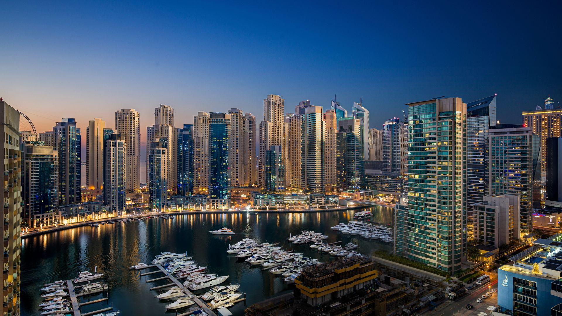 Dubai Marina skyline at dusk with boats in the harbour
