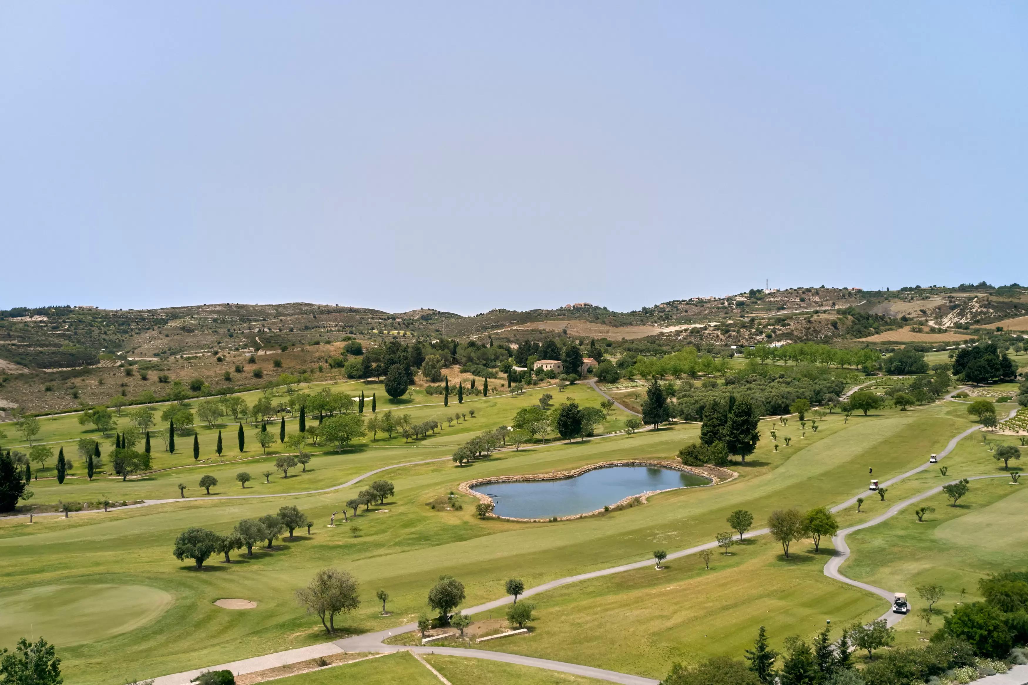 Birdseye view of wife fairways and smooth green under blue skies at the Minthis Resort