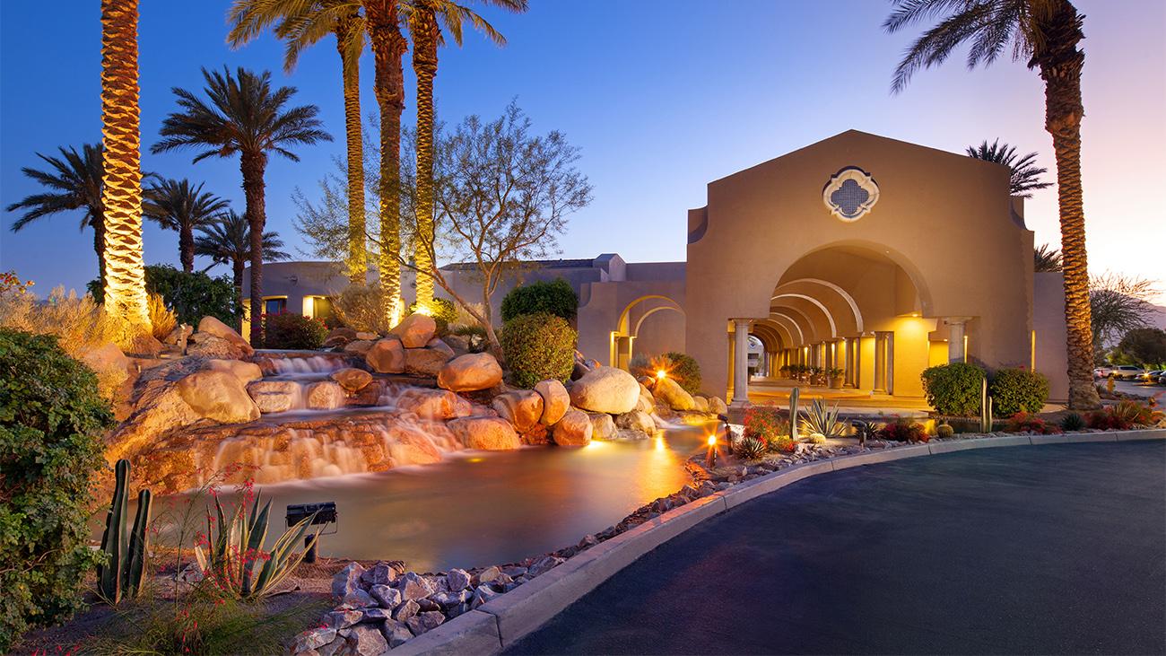 Grand front entrance to the Mission Hills resort with a luxurious archway and stone water fountain