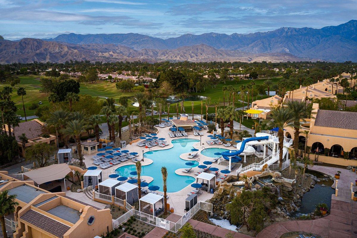 Aerial view of the resorts swimming pool alongside their on sight golf course with mountain views in the distance