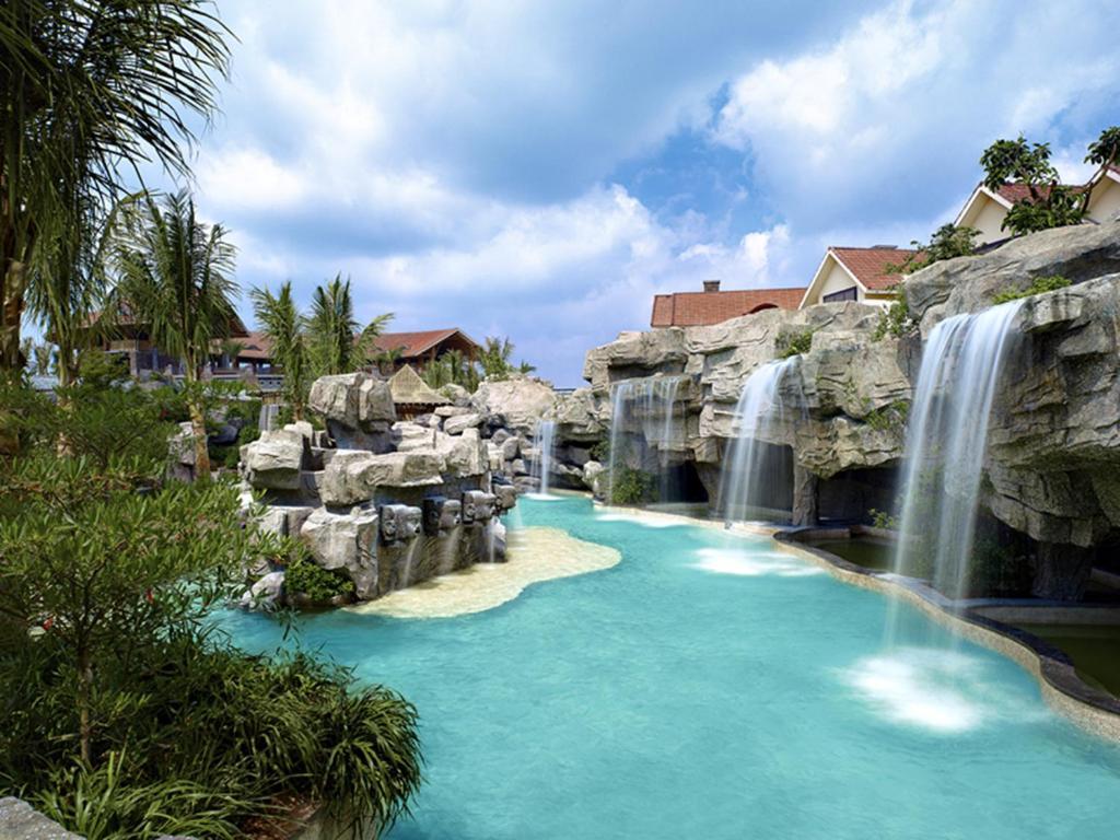 An outdoor swimming pool with rock water fountains
