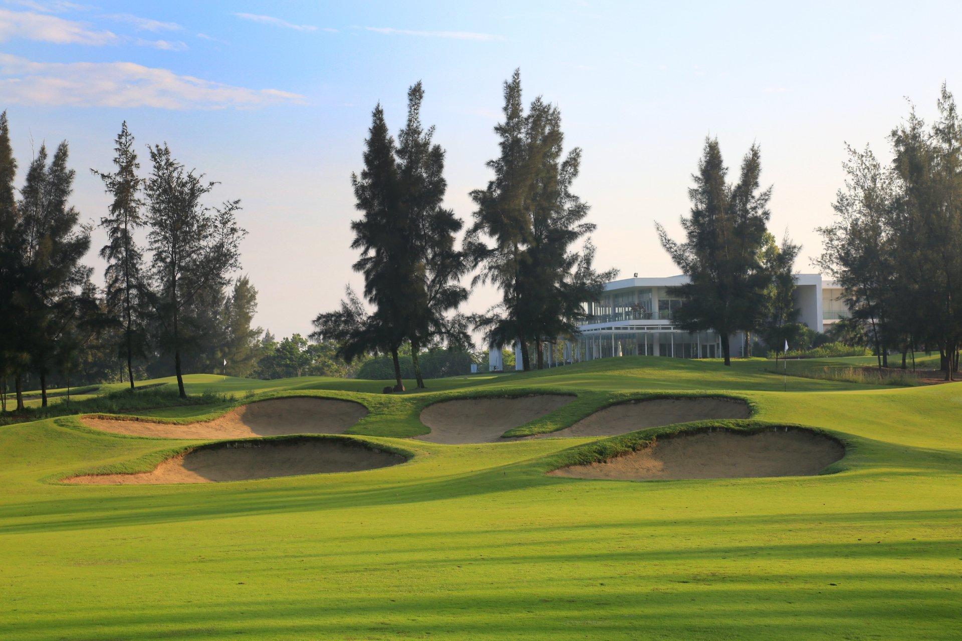 A modern clubhouse overlooking neatly manicured golf greens.