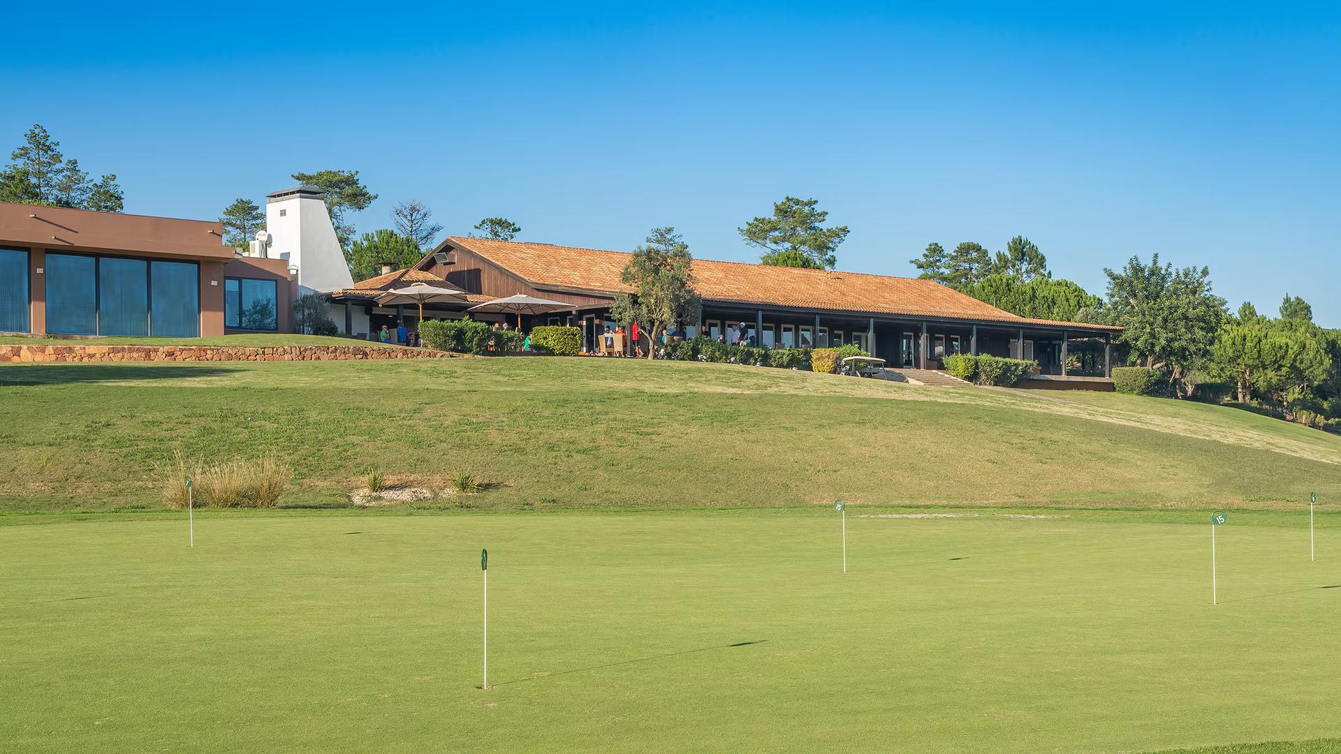 Putting green with the clubhouse in the backgroun